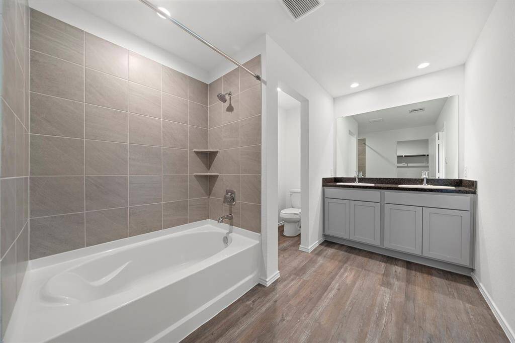 The primary bathroom with double sinks and a shower/tub combo.