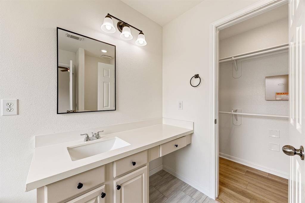 This primary bathroom is definitely move-in ready! Featuring cream cabinets with light countertops, spacious walk-in closet with shelving, neutral paint with sleek and dark modern finishes.