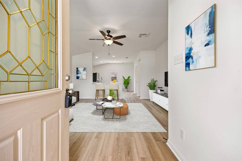 Upon entering you find are welcomed by the open floor plan with beautiful wood-like floors, high ceilings and ample lighting.
