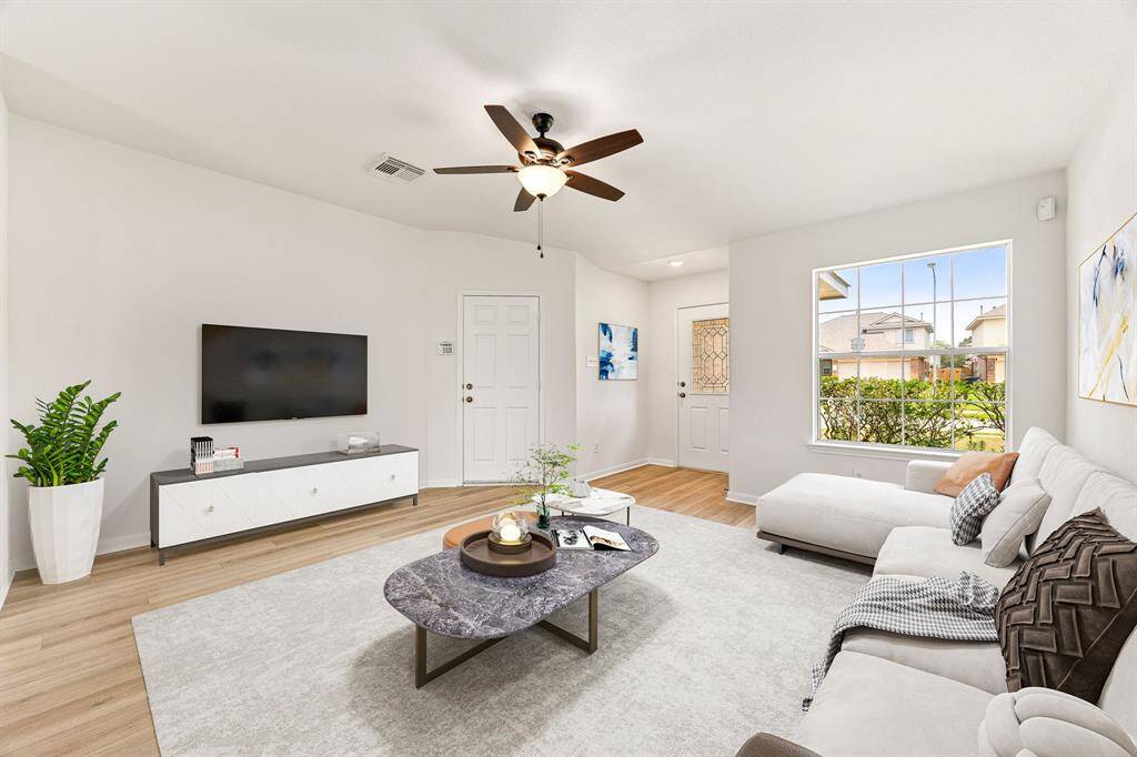 Gather the family and guests together in your lovely living room! Featuring dark stained ceiling fan, neutral paint, gorgeous wood like floors and large windows that provide plenty of natural lighting throughout the day.