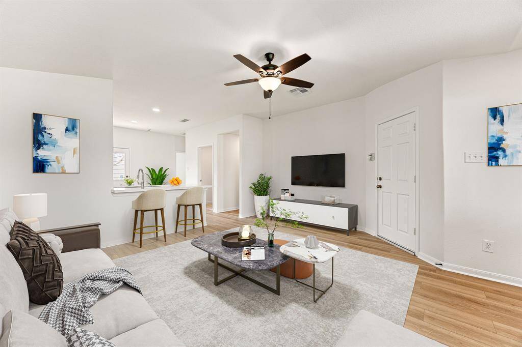 This light and bright spacious living room is the perfect layout for entertaining or just relaxing. Whether it's simply a night in or entertaining family and friends, this home has ample open space for everyone to enjoy! Featuring dark stained ceiling fan, wood like flooring, large window with blinds with wonderful access to your gorgeous kitchen.