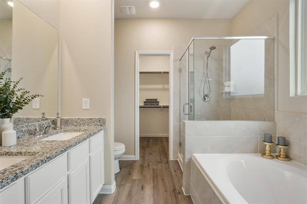 The primary ensuite bathroom offers a luxurious escape with a dual sink vanity, a relaxing soaking tub, and a separate walk-in shower. You’ll also find a spacious walk-in closet for added convenience.