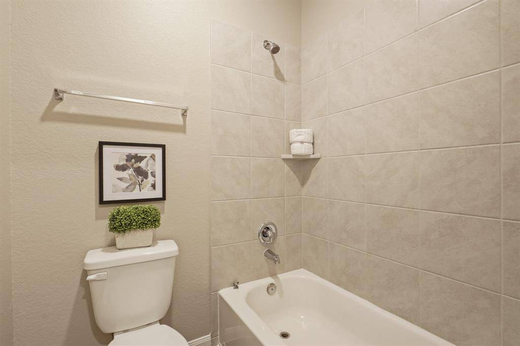 The guest bathroom upstairs is designed for easy sharing, featuring a private water closet with a tub/shower combination and toilet. This thoughtful layout adds convenience and privacy for busy mornings or visiting guests.