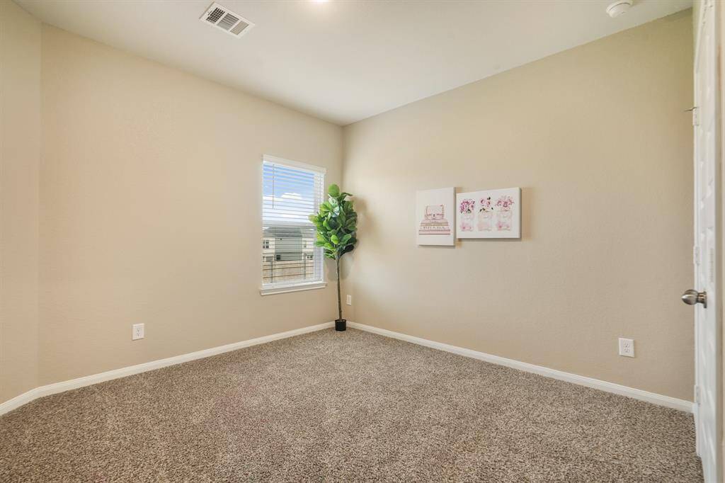 This upstairs guest room offers a peaceful retreat with soft carpet, neutral tones, and a spacious closet. As one of three secondary bedrooms, it also enjoys easy access to a nearby full bathroom for added convenience.