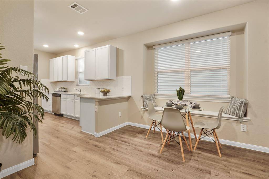 The cozy dining nook is perfectly placed beside a wide window with a built-in ledge, creating a charming spot for casual meals or morning coffee. This light-filled space sits just off the kitchen, offering everyday convenience and comfort.