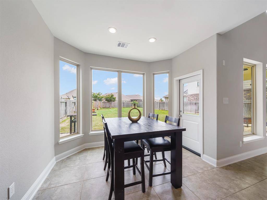 Charming dining room, conveniently located off the kitchen, awaits you. A delightful bay window floods the space with natural light, offering serene views of your private backyard.