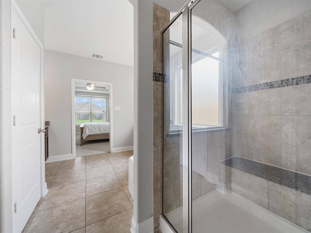 The spacious bathroom boasts an oversized shower with a built-in bench.
