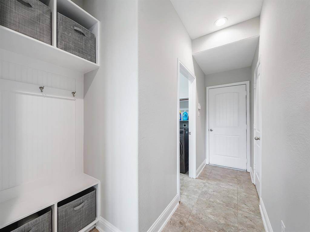 This home boasts a thoughtfully designed MUD hall featuring a built-in organizer, perfect for keeping clutter at bay and streamlining your daily routine.