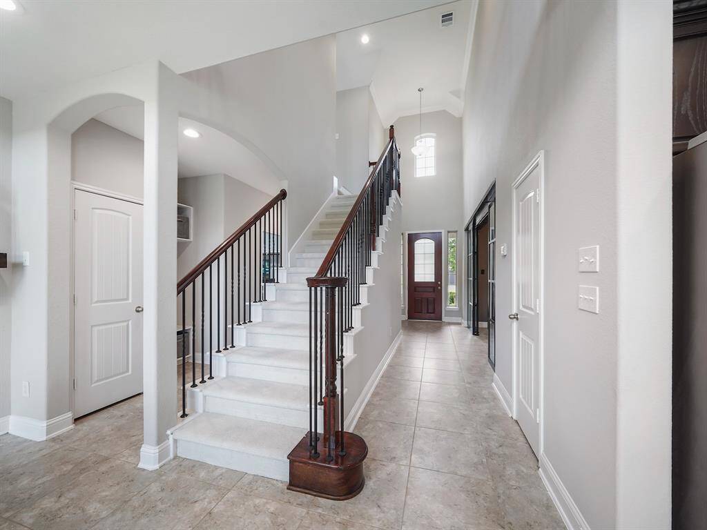 This captivating view showcases the entryway's architectural charm, with the staircase taking center stage. Notice the delicate wrought iron spindles that add a touch of sophistication.