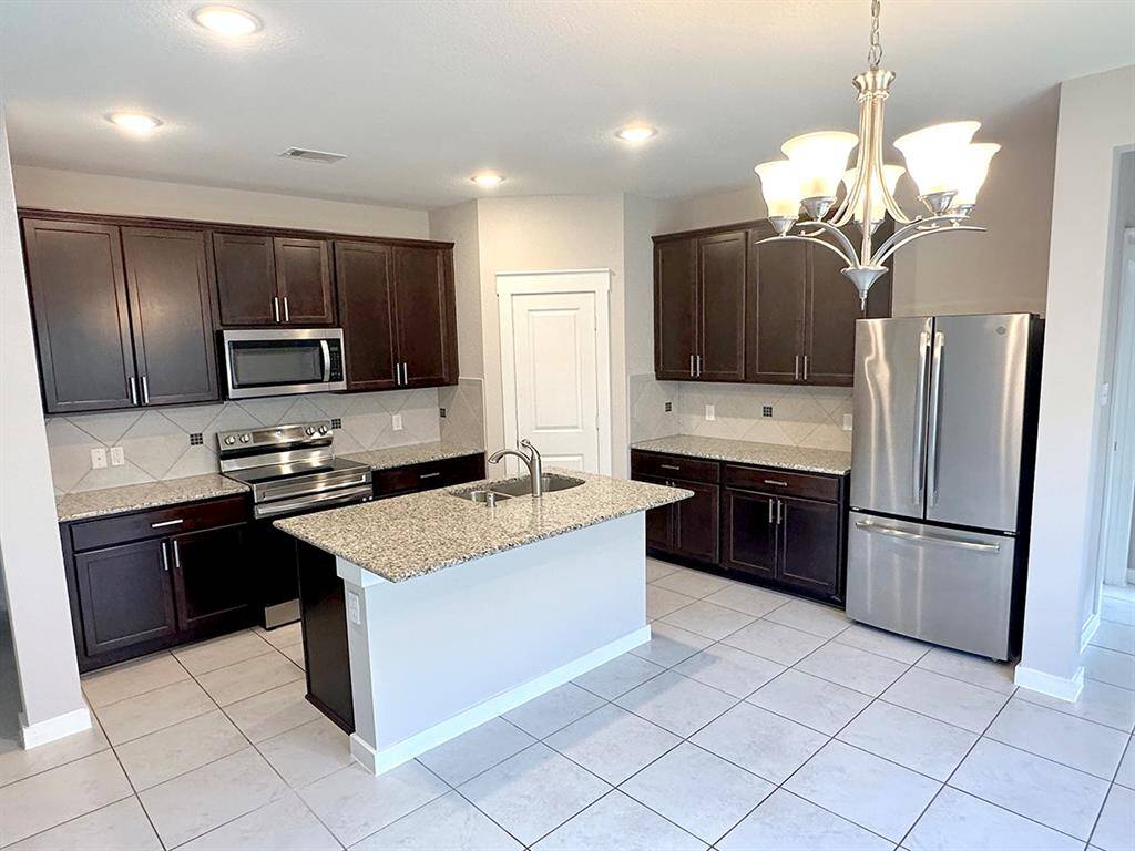 Kitchen with breakfast bar. SS appliances. Electric range / oven is now installed