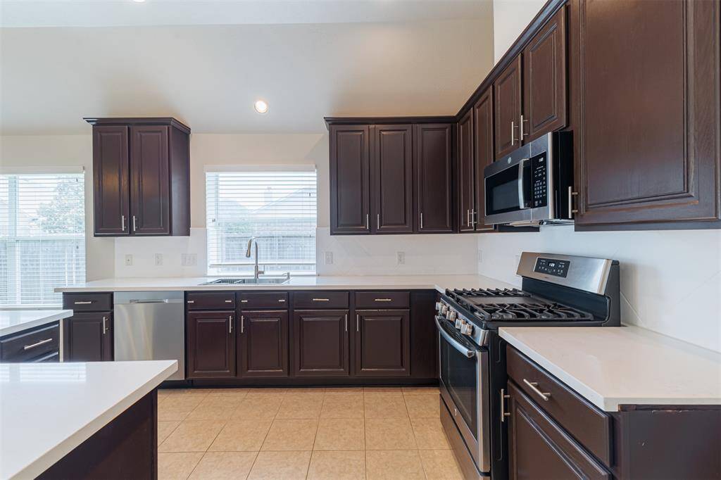 The remodeled kitchen features quartz countertops and stainless steel appliances.