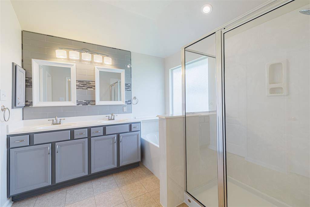 The ensuite bath features dual vanities, a garden tub, and a separate walk-in shower.