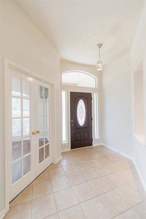 Tiled entry that opens to a private study with French doors