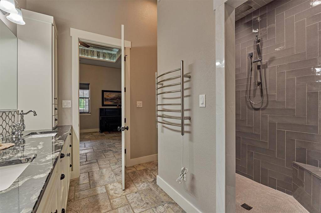 A peek into the walk in shower complete with modern tile walls and comfortable penny tile flooring.