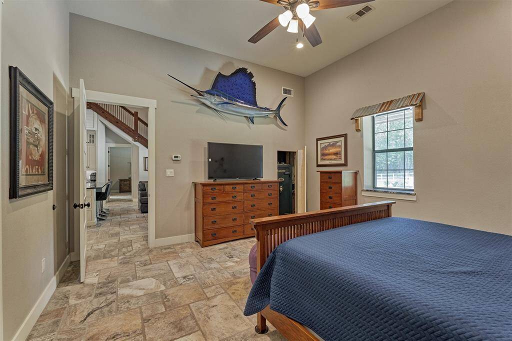 A first-floor guest bedroom is located on the other side of the home and offers a spacious walk-in closet. Unique features include a rustic-style awning accenting the window and a cleverly designed hidden space tucked behind a wall shelf—adding both charm and functionality.