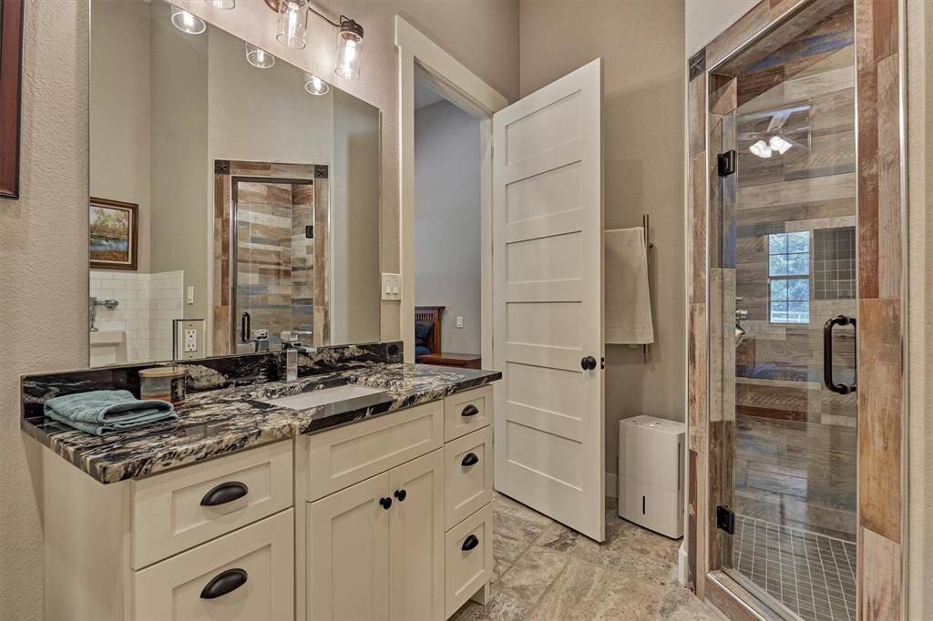 The full bath off of the guest room features finishes that tie in the rustic modern style.