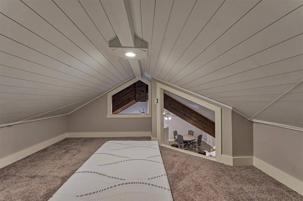 A cozy loft area with cutouts overlooking the game room and living room is a cute space for a play room or for extra sleeping space! The ceiling is 7' high at the tallest point in this space.