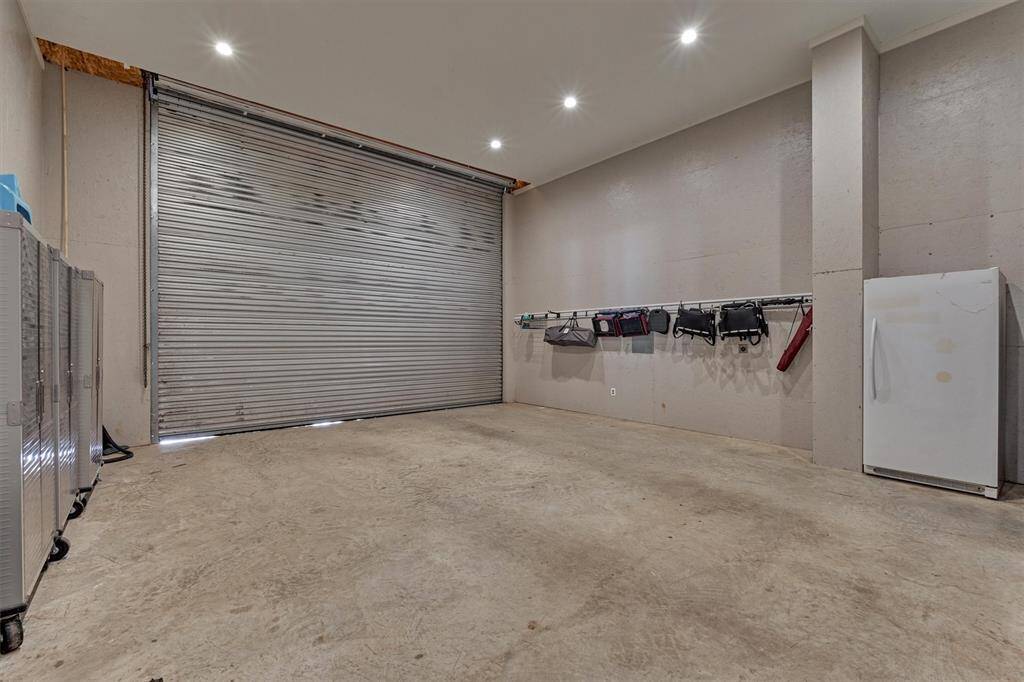 The garage attached to the home has a large roll up door measuring 14' high and 18' wide with a high ceiling for taller vehicles.