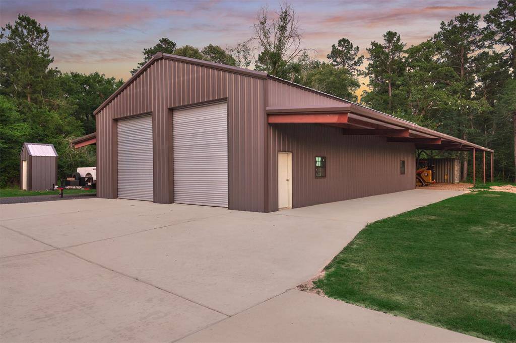 A separate shop features two 14' roll-up doors and 10' eaves on both sides, providing ample space for covered storage and easy access.