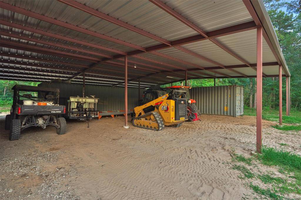 A covered area behind the shop provides additional storage. The two metal storage containers are included in the sale.