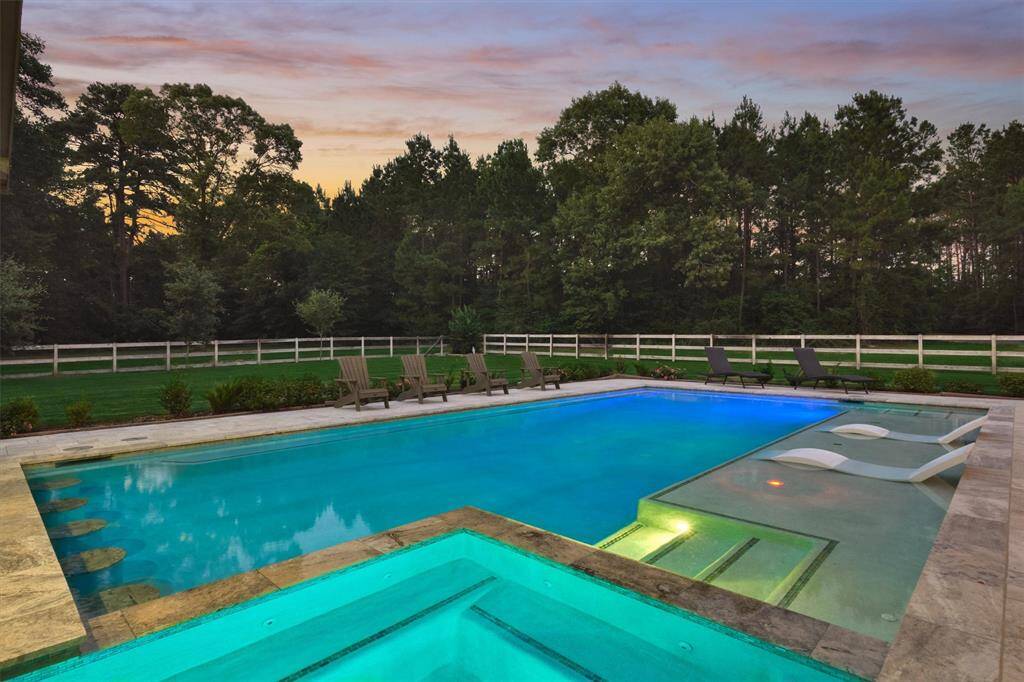 Another view of the sparkling pool and fenced yard showcases a true entertainer’s dream. There's plenty of space for gatherings and relaxing in a private, inviting setting.
