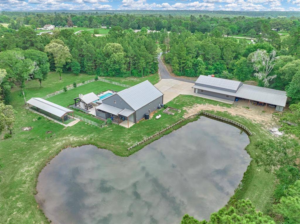 Aerial view of the home, pool, batting cage, shop and pond.