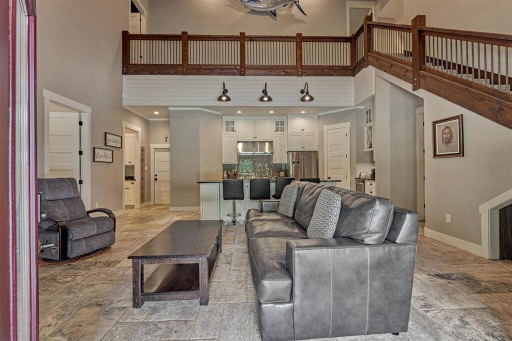 Enter the home to an open and inviting living area, where soaring ceilings create an airy, spacious feel. Timeless travertine flooring flows throughout the first floor, adding an elegant and cohesive touch to the home’s design.