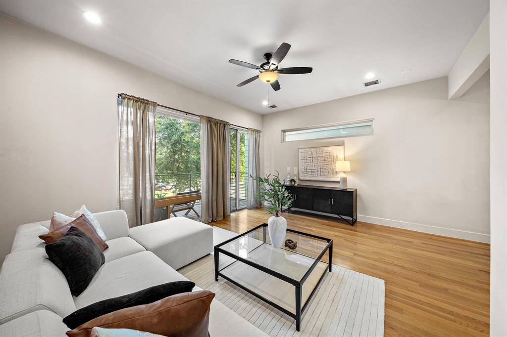 Light hardwood floors, soft neutral walls, and a modern ceiling fan combine for a relaxed yet elevated atmosphere ideal for city living.