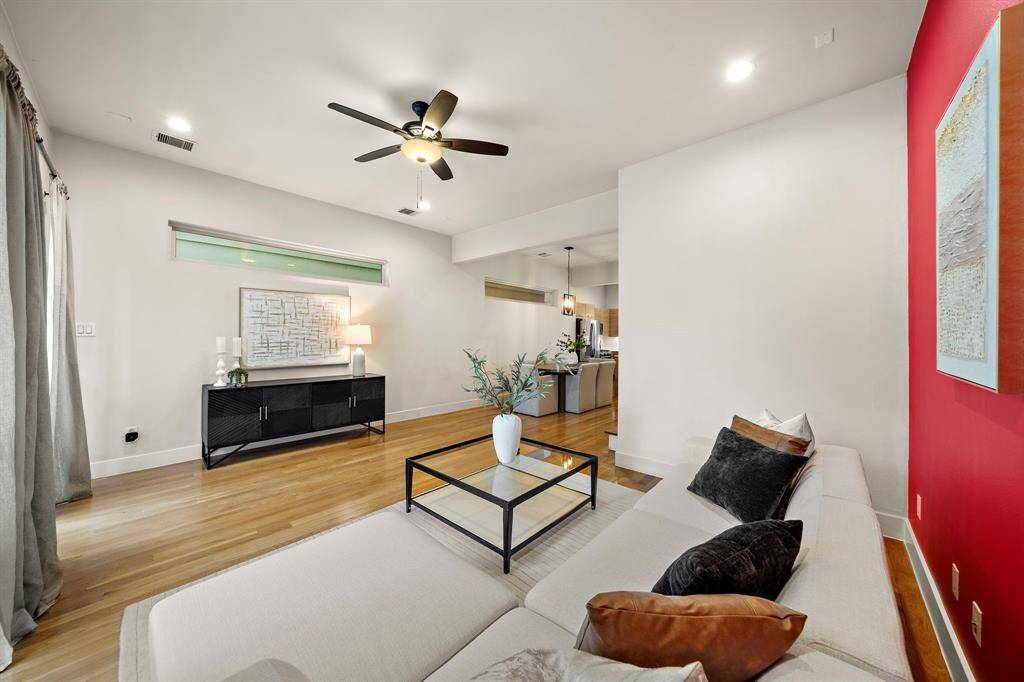 The layout flows to the kitchen and dining area, while large windows and a ceiling fan ensure comfort and style throughout the day.