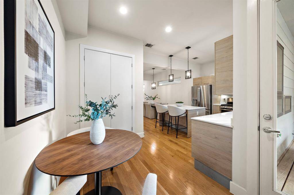The breakfast area offers convenient proximity to the kitchen, with a stylish round table and direct access to the adjacent outdoor space.