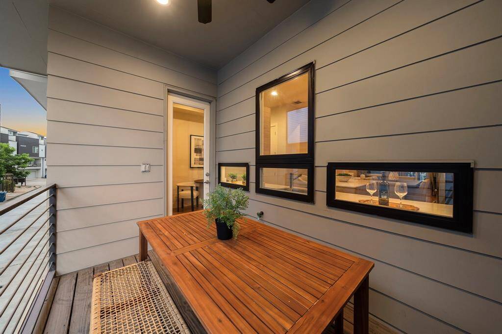 Step outside to this private balcony featuring contemporary horizontal railings and durable wood decking, ideal for open-air dining or unwinding with neighborhood views.