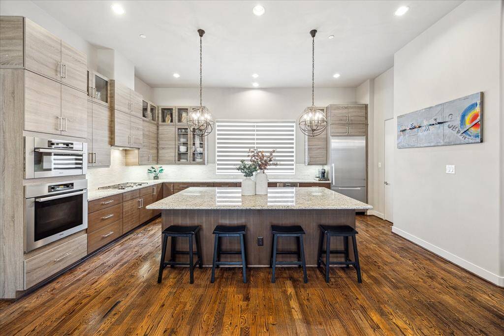 This chef-inspired kitchen offers exceptional space for cooking and gathering, featuring a large granite island, custom cabinetry, and under-cabinet lighting that adds both function and ambiance. A built-in coffee bar and generous pantry provide added convenience, making this kitchen as practical as it is stylish.