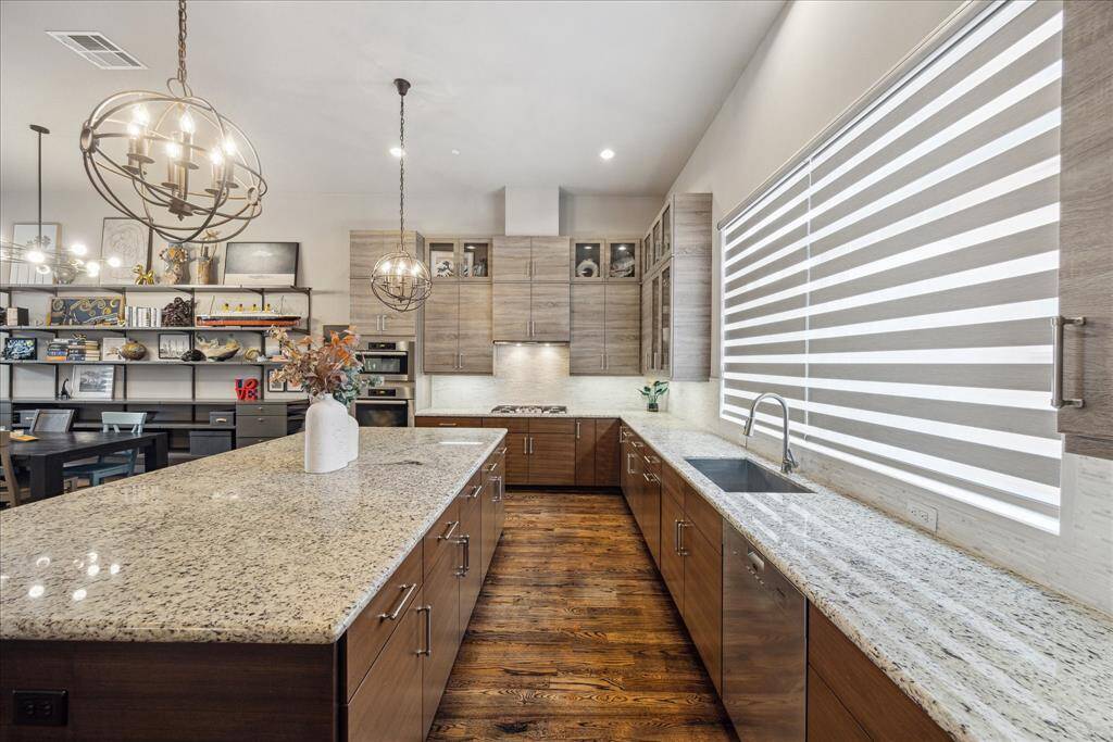 Framed by custom window treatments designed to complement the home's modern aesthetic, this kitchen is bathed in natural light and thoughtfully laid out for both function and flow. The spacious island invites gathering, while layered lighting and clean design make this the true heart of the home.