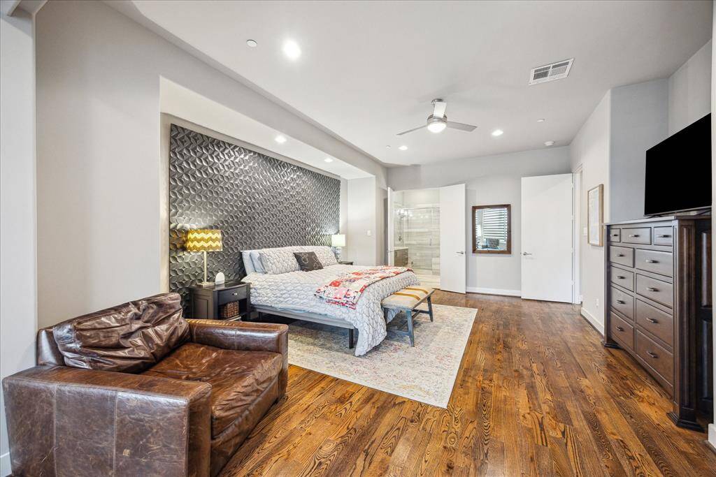 A peaceful sanctuary designed with both comfort and sophistication, this primary bedroom features rich finishes and thoughtful touches throughout. From the textured accent wall to the stylish lighting, every detail enhances the room’s inviting atmosphere. A private en suite bath completes this refined retreat.