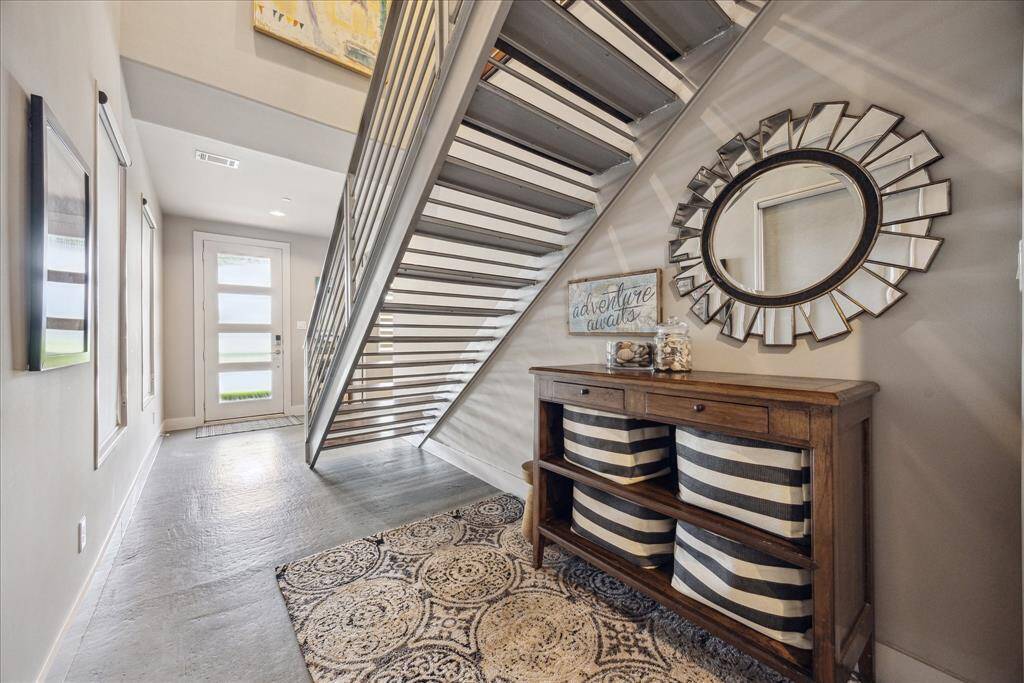 Experience a modern entryway designed to impress, featuring a sleek staircase and clean architectural lines that highlight the home’s open, contemporary style from the moment you arrive.