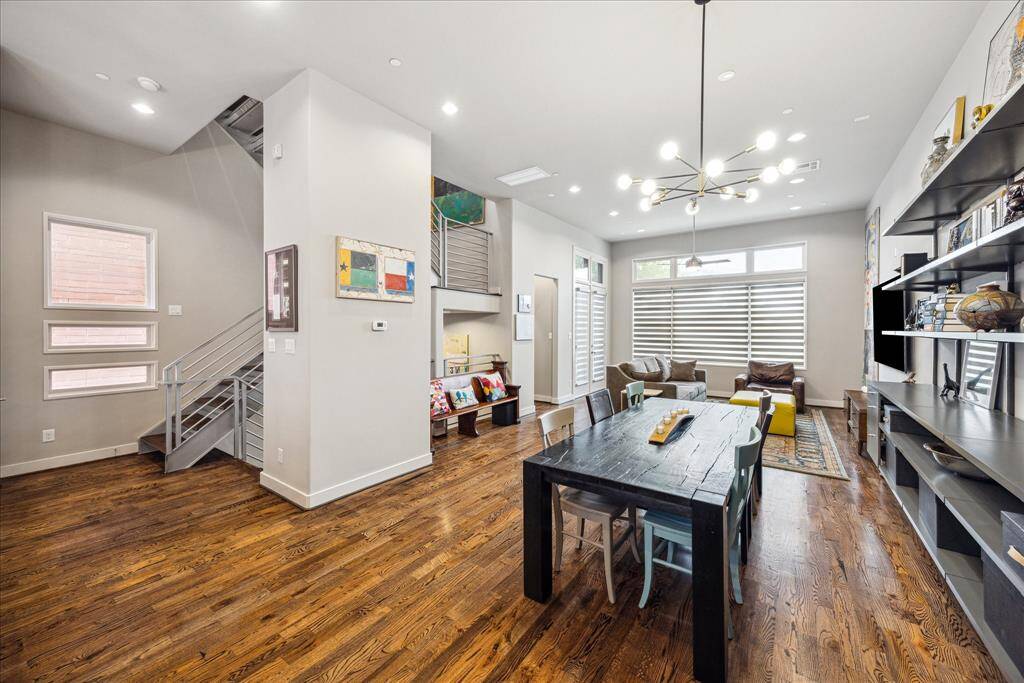 A true show-stopper, this open-concept living space stuns with rich wood flooring, soaring natural light, and seamless flow from dining to lounging. Sleek architectural lines, a statement staircase, and designer lighting set the tone for modern elegance and effortless entertaining.