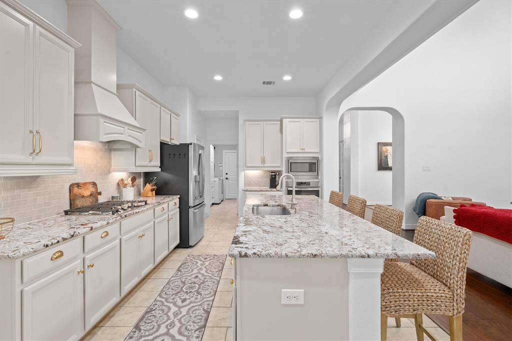 Beautifully designed, the open-concept kitchen seamlessly flows into the family room – perfect for hosting and everyday gatherings. Updated with modern appliances, freshly painted cabinets, and sleek new hardware, this space effortlessly blends style and functionality. Generous counter space makes meal prep a breeze, while the open layout keeps you connected to the heart of the home.