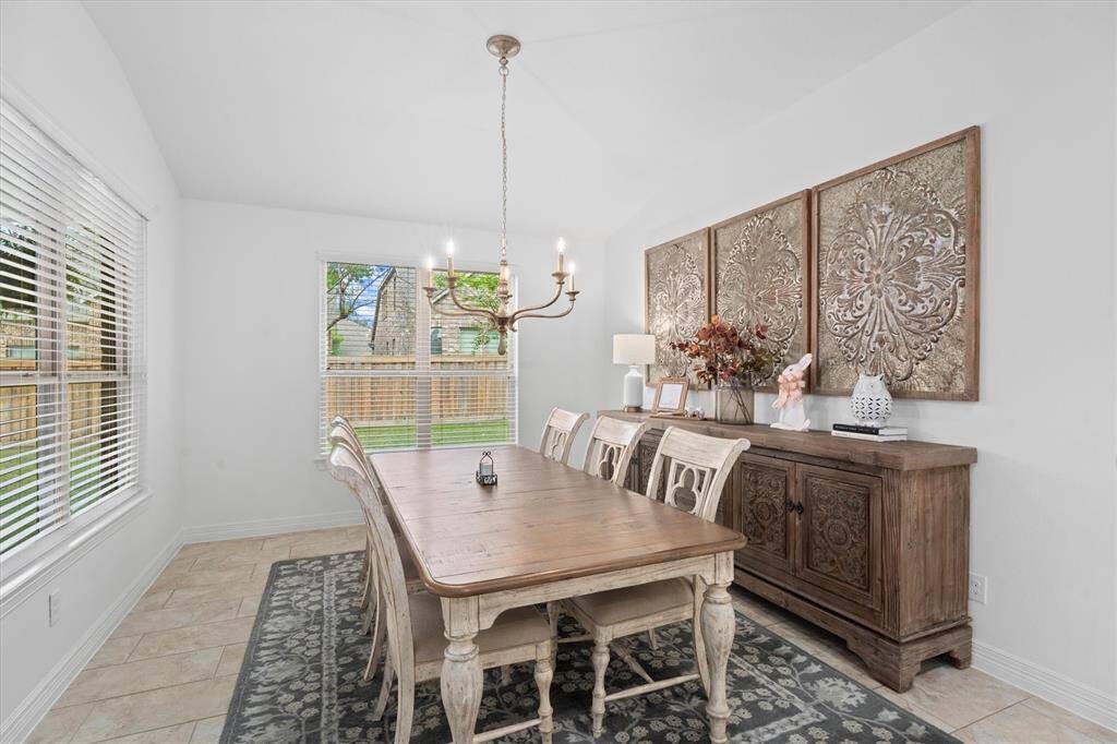 Just off the kitchen, the expansive breakfast room offers an impressive amount of space – perfect for casual dining or morning coffee. The room is beautifully accented by a statement chandelier, adding a touch of elegance to this bright and welcoming area.