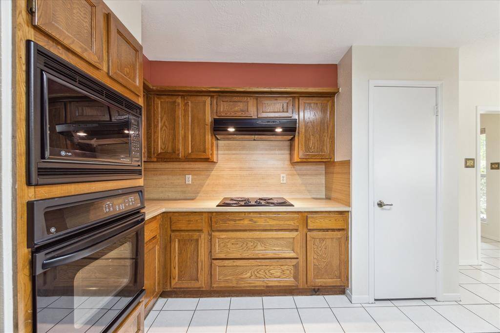 This thoughtfully designed kitchen is outfitted with a large pantry and sleek black appliances including a built-in oven, microwave, electric cooktop, and dishwasher making meal prep and clean up a breeze. With everything you need within easy reach, cooking here is as convenient as it is enjoyable.