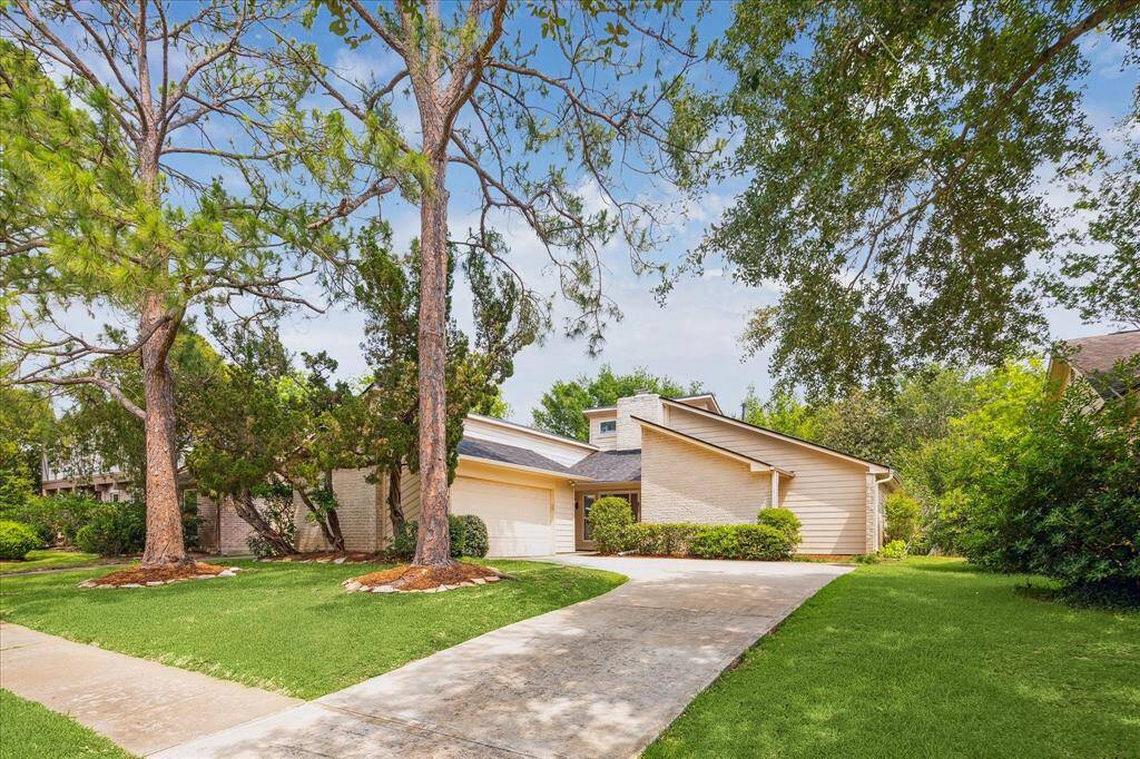 Towering trees, manicured landscaping, and a split-gable elevation give this home standout curb appeal. The wide driveway leads to a 2-car garage while the welcoming covered entry sets the tone for life in this beautiful, well-established neighborhood.