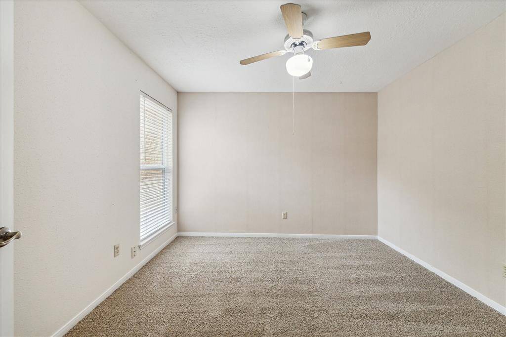 An alternate view of the spacious guest bedroom reveals plenty of floor space—perfect for furniture, games, toys, or simply stretching out and relaxing.