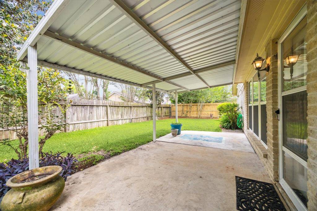 Enjoy summer BBQs and back yard birthday parties with this charming covered patio with a lit ceiling fan and plenty of room for a grill and seating for friends and family.