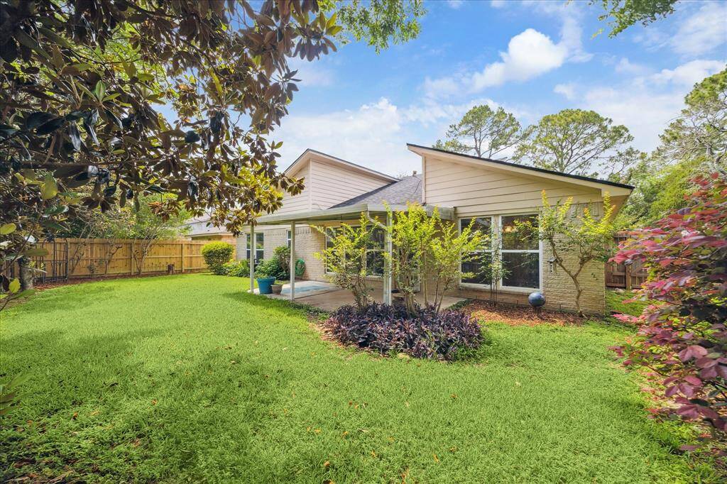 Step outside to your own private retreat! This lush backyard features mature landscaping, vibrant foliage, and a covered patio, perfect for outdoor dining, relaxing in the shade, or hosting weekend gatherings with friends and family.