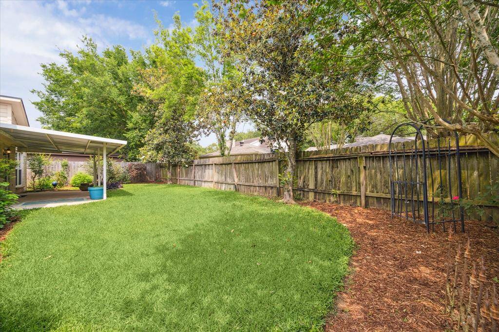 This sprawling fenced yard is ready for barefoot fun with plenty of grassy lawn for outdoor play.