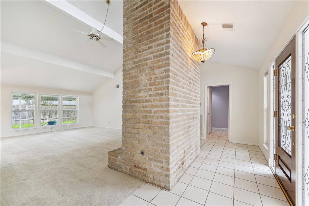 It will be love at first sight! From the leaded glass front door to the soaring ceiling and striking brick fireplace, this entry offers a stunning introduction to the stylish, light-filled interior that lies ahead.