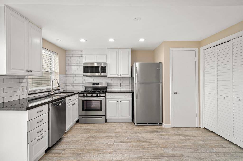Prepare meals in style with stainless steel appliances, granite countertops, and abundant cabinetry. A dedicated pantry offers convenient storage, while the open layout includes direct access to a private fenced patio—perfect for outdoor dining or entertaining guests.