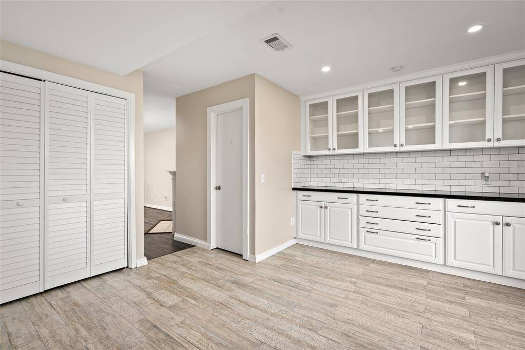 Flowing effortlessly from the living area, this section of the kitchen offers a stylish blend of open shelving and ample storage. The nearby half-bath downstairs half bath, conveniently positioned near the kitchen and living area. A perfect spot for guests or quick use without heading upstairs.