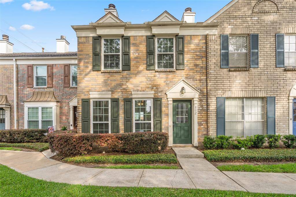 Classic brick exterior with traditional design elements and a covered front entry. Evening lighting highlights the home’s clean lines, well-kept landscaping, and welcoming walkway in this quiet, well-located community.