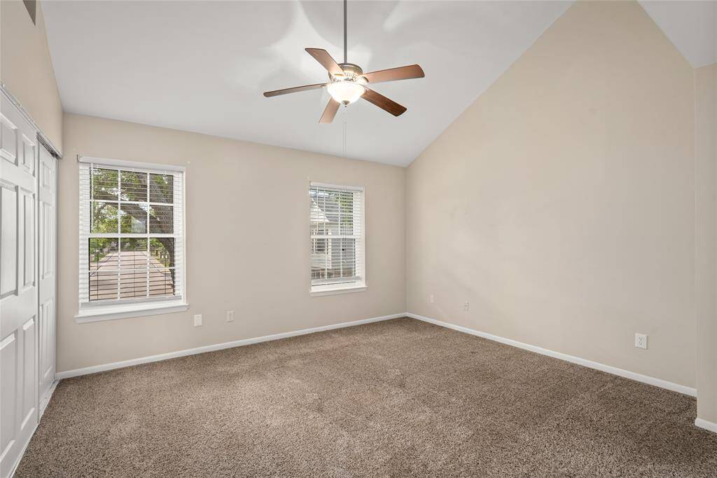 This inviting primary bedroom features two large windows that fill the space with natural light and offer a serene view of the outdoors. The room boasts generous dimensions and includes a walk-in closet, providing ample storage and organization space. A perfect retreat for rest and relaxation.