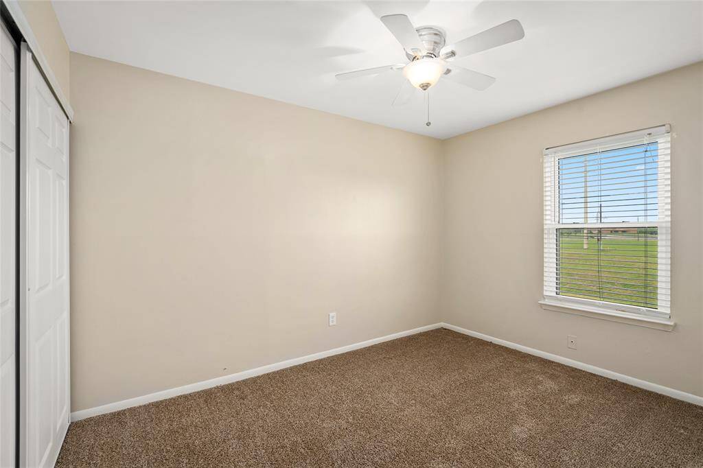 Bright and cozy, this secondary bedroom features a large window with beautiful outdoor views, a ceiling fan for added comfort, and a spacious sliding-door closet. Neutral tones and plush carpeting make it a versatile space perfect for a guest room, home office, or nursery.